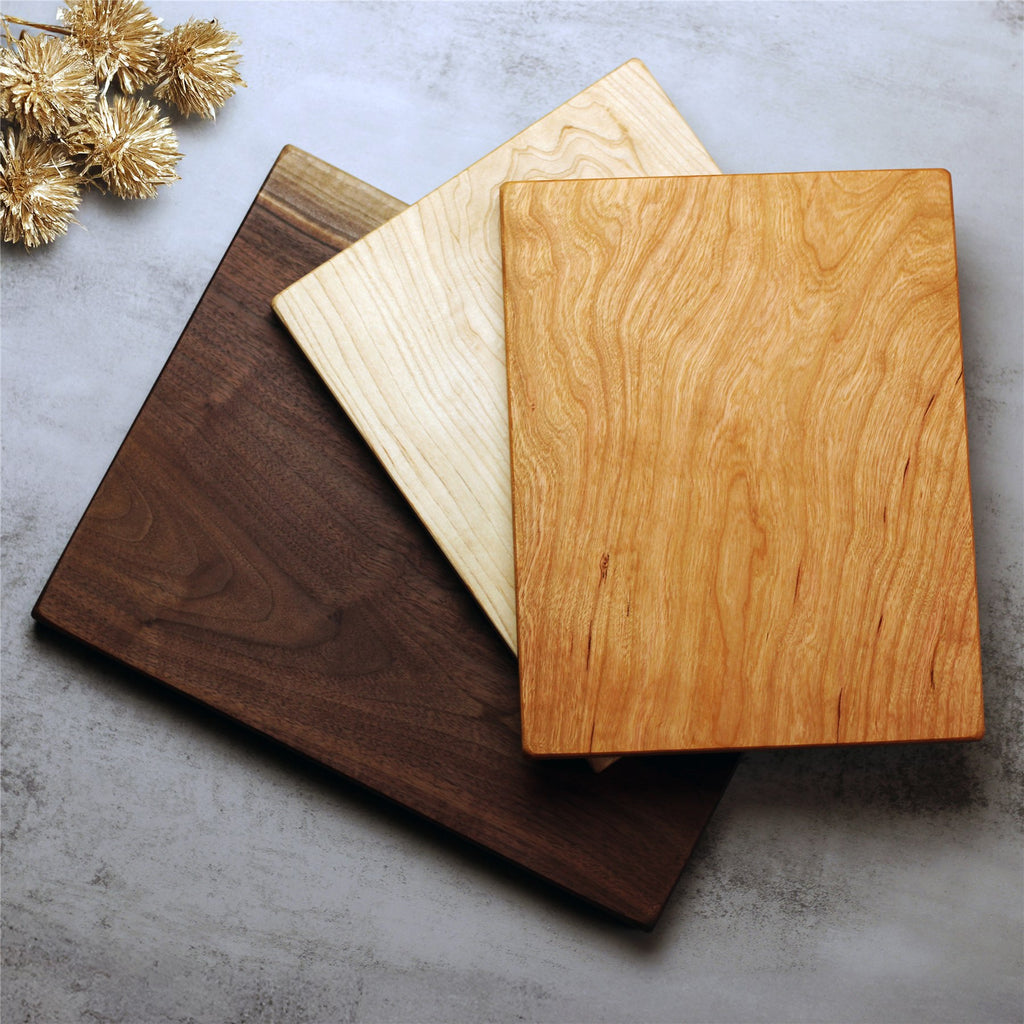 One-piece cutting boards in walnut, maple, and cherry, showing the three natural wood colors